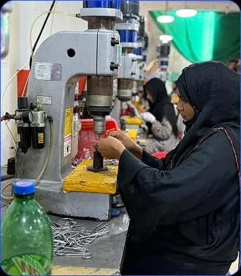 Woman operating an industrial press on a manufacturing line