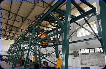 Green steel framework and pulley system inside a factory hall