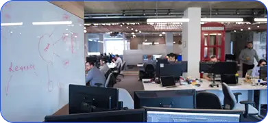 Open-plan office workspace with desks and monitors