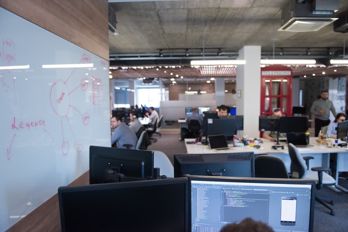 Open-plan office workspace with desks and monitors