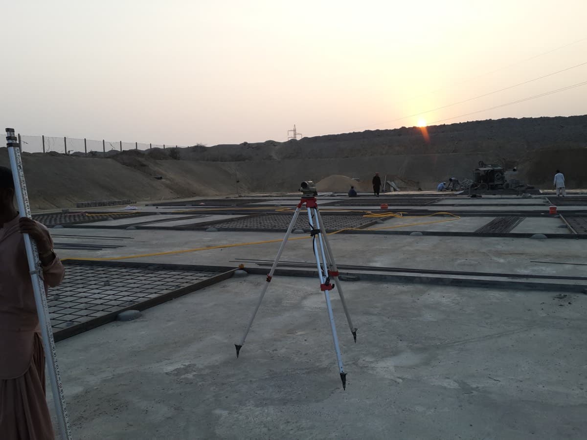 Surveying equipment on a construction site at dusk