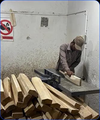Craftsperson shaping a cricket bat on a woodworking machine